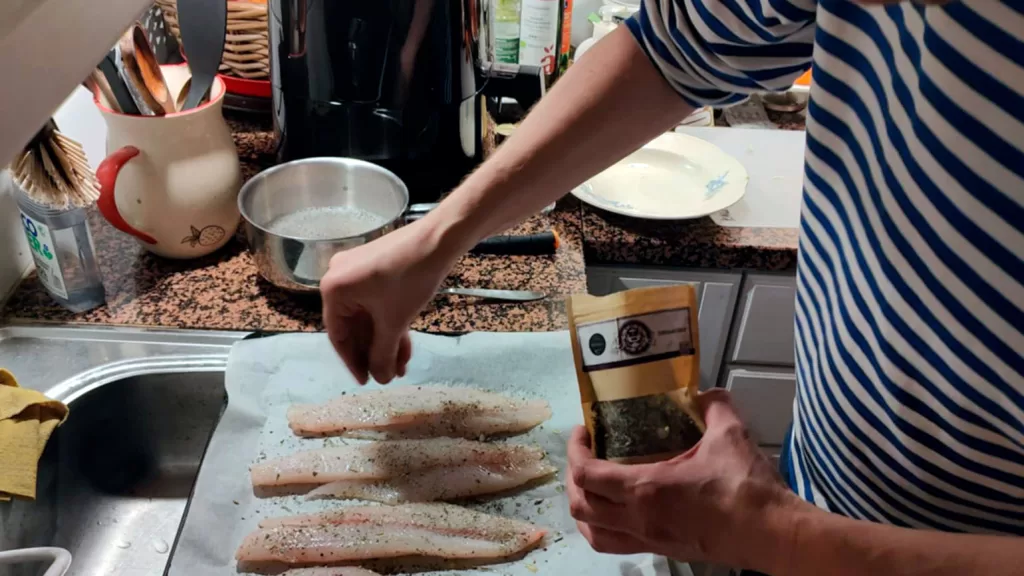 Keittiössä kokki valmistaa kalaruokaa